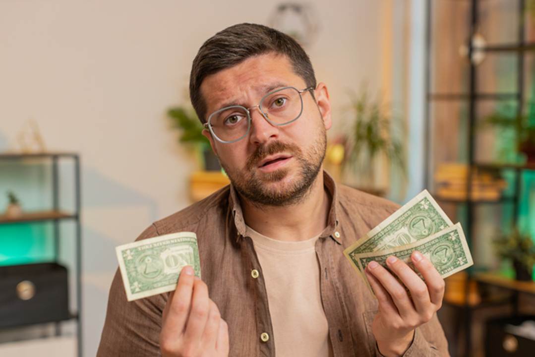 Man holding small amount of money - Unpaid Wages